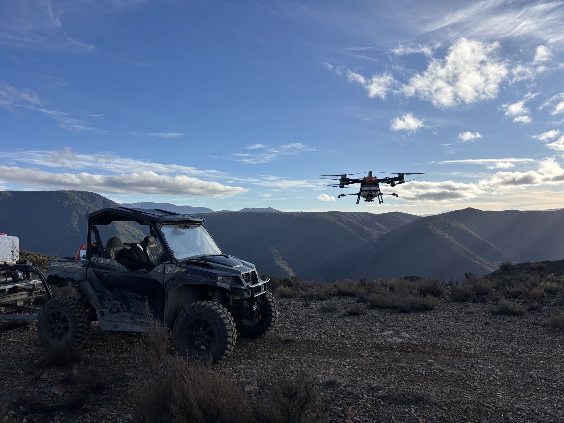Sunrise Drones side-by-side and spray drone working high in the hill country